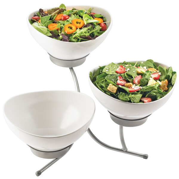A Cal-Mil three tier display stand with white round bowls of salad on it.