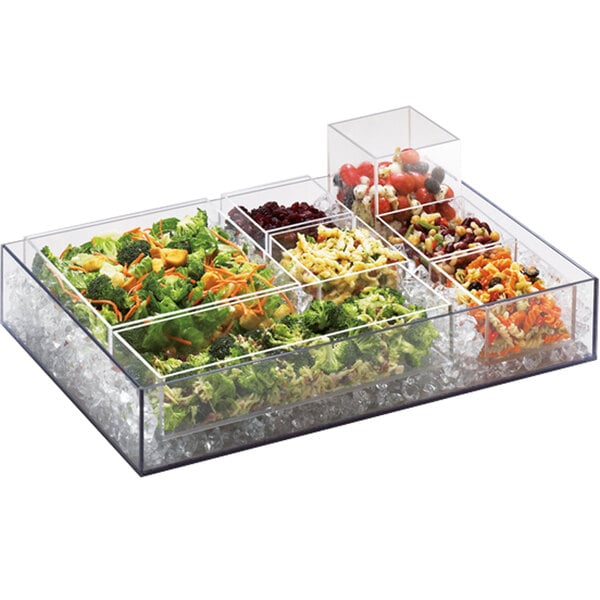 A clear plastic container of a variety of food on a counter in a salad bar.