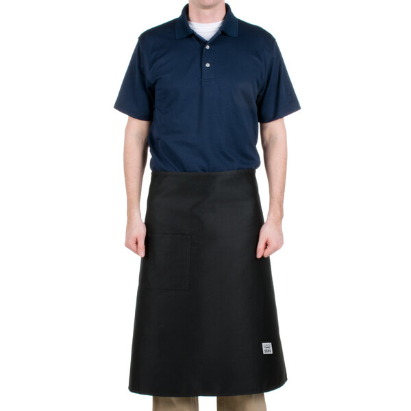 A man wearing a black Chef Revival bistro apron with a pocket.