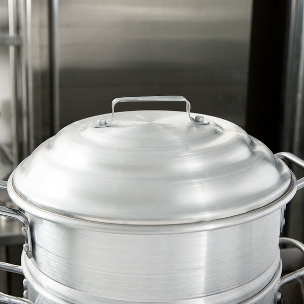 A silver aluminum steamer cover on a silver pot.
