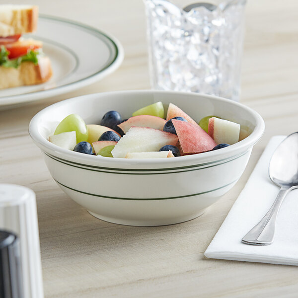A bowl of fruit salad in a Tuxton Green Bay china bowl with green bands.
