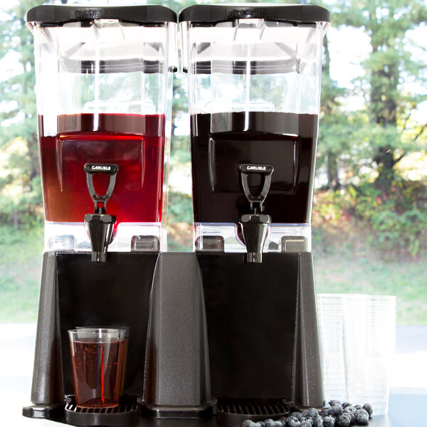 A Carlisle TrimLine double plastic beverage dispenser with juice in it.