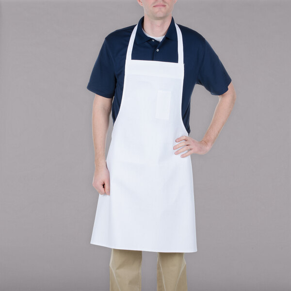 A man wearing a white Chef Revival bib apron with a pocket.