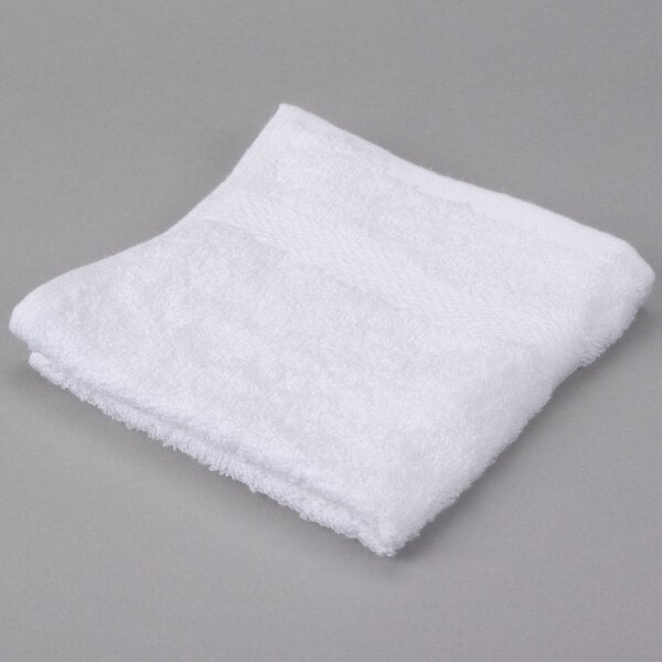 A pack of white Oxford Regale wash cloths on a gray surface.