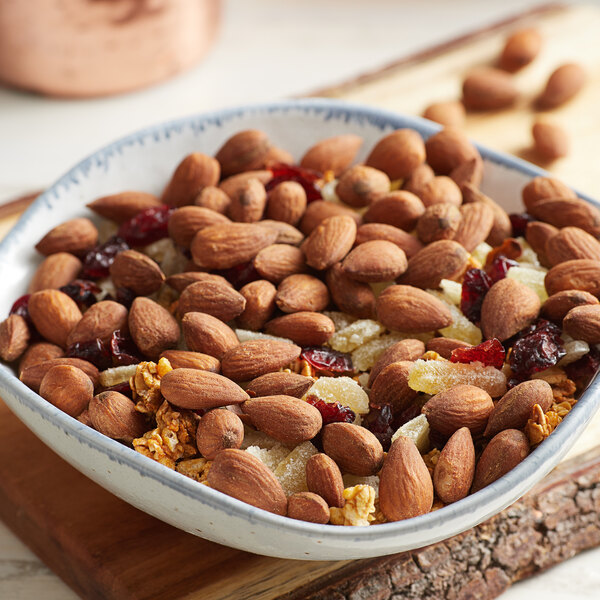 A bowl of Blue Diamond roasted salted whole almonds and dried fruits on a table.