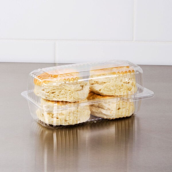A Dart clear plastic high dome oblong container filled with biscuits.