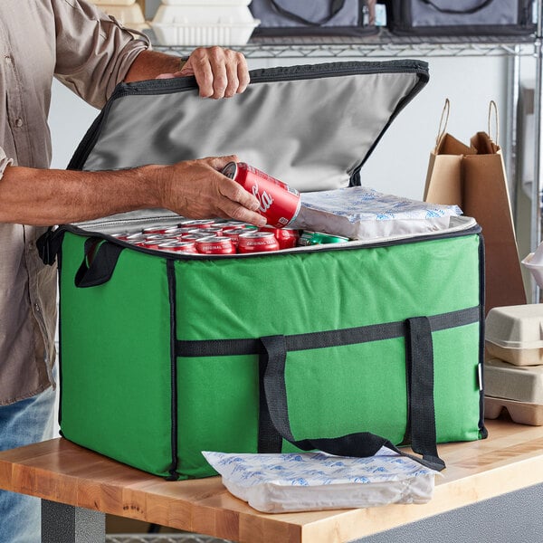 A man putting a can into a green Choice insulated cooler bag.