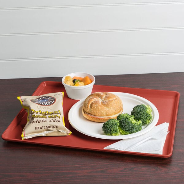 A Cambro raspberry cream dietary tray with food on it.