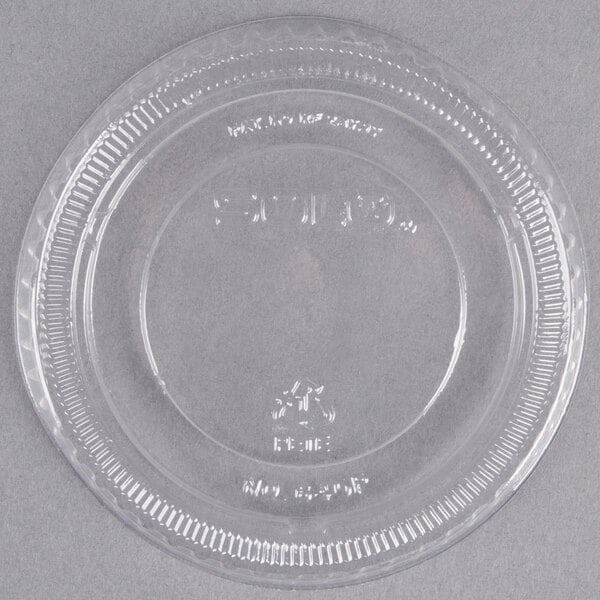 A clear Solo plastic lid on a clear plastic plate.