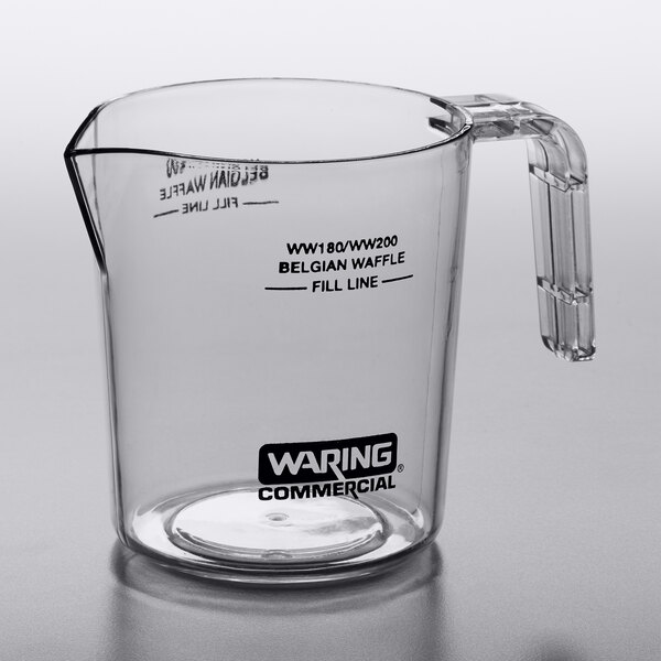 A clear glass measuring cup with handle.