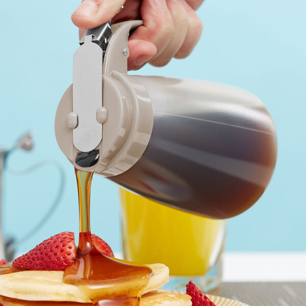 A person pouring Tablecraft syrup on pancakes.