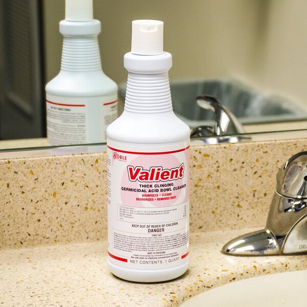 A white bottle of Noble Chemical Valient Ready-to-Use Disinfectant Toilet Bowl Cleaner with red and black text on a bathroom counter.