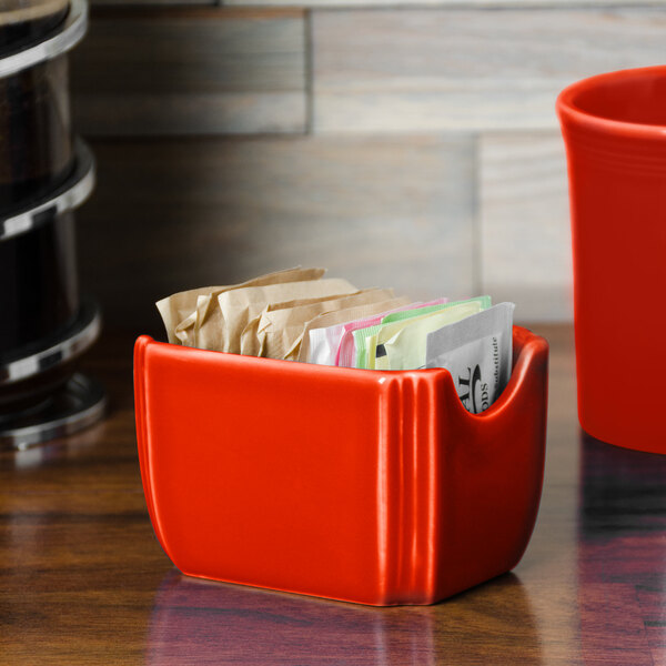 A red Fiesta sugar caddy holding packets.