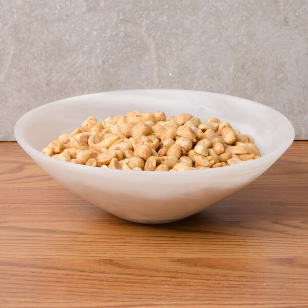 An American Metalcraft Translucence Collection round bowl filled with peanuts on a table.