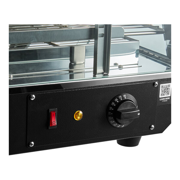 A black countertop heated display case with a temperature control knob, power switch, and glass shelves.