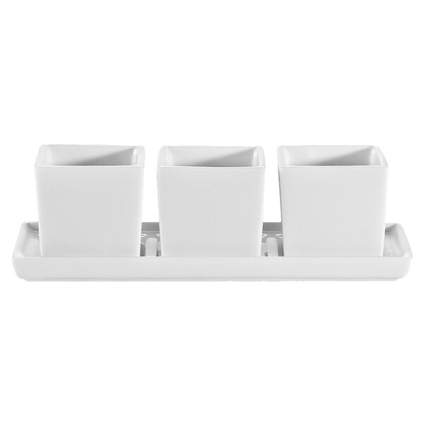 A white tray with three white square bowls inside.