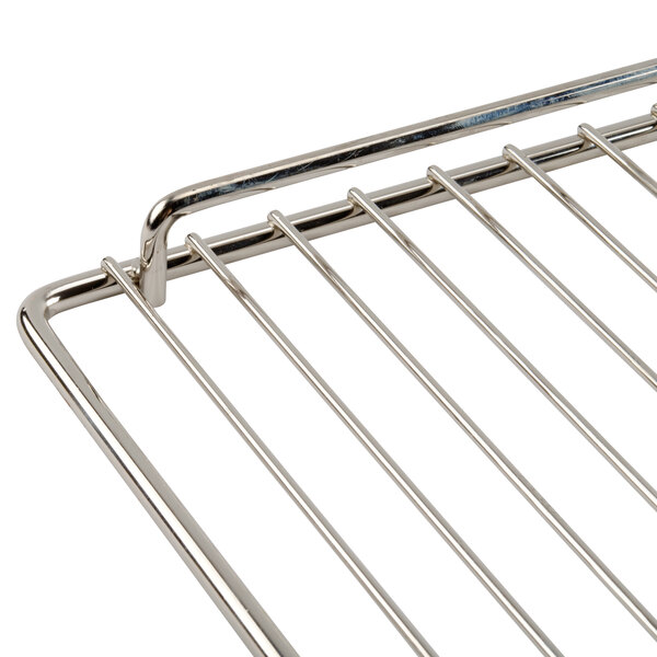 A stainless steel wire rack with a handle for an Avantco countertop food warmer.