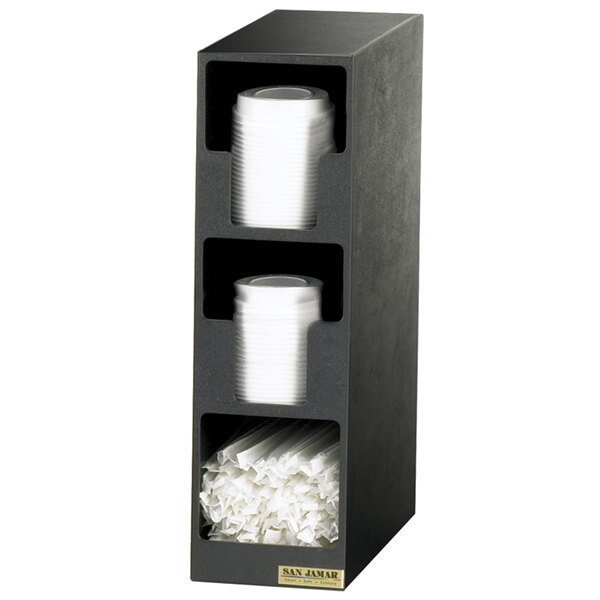 A black San Jamar countertop lid organizer with white plastic cups and straws in it.