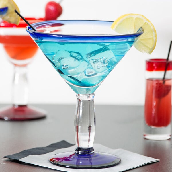 A Libbey martini glass with a blue drink and a lemon slice.