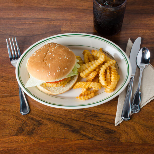 A Homer Laughlin green banded oval platter with a burger, lettuce, and tomato.