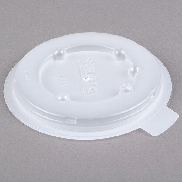 A white plastic lid with a hole on top.