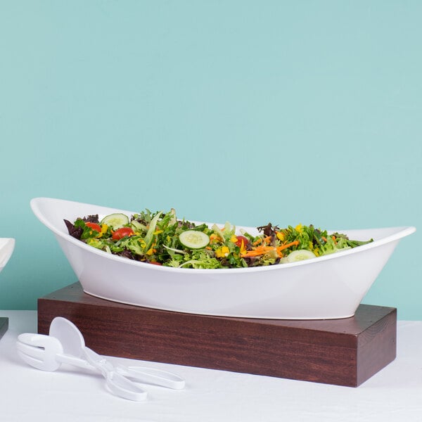 A Tablecraft white melamine bowl with salad on a table.