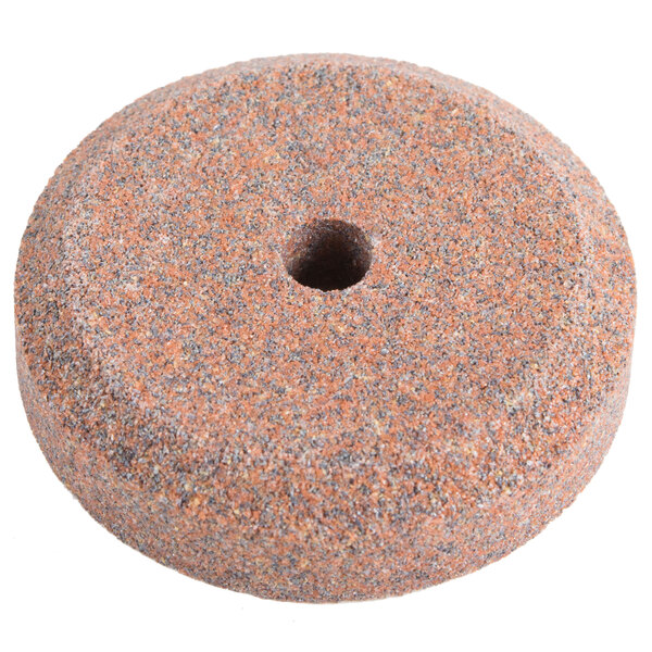A circular sharpening stone with a hole in the middle.