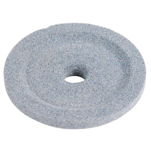 A circular gray stone grinding wheel with a hole in the center.