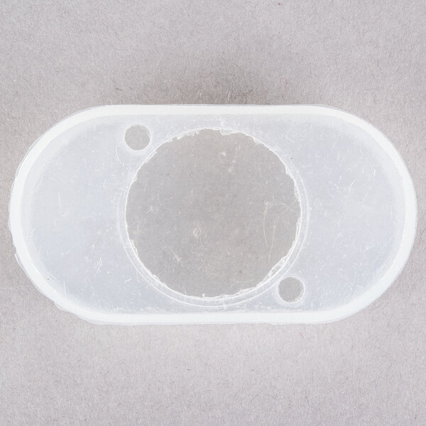 A white plastic circle with holes in it.