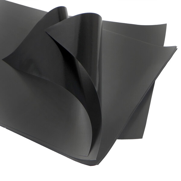 A stack of black sheets of paper with a folded edge.