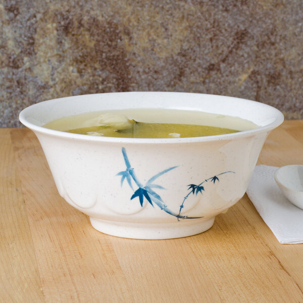 A blue and white Thunder Group Blue Bamboo melamine bowl filled with soup on a table.