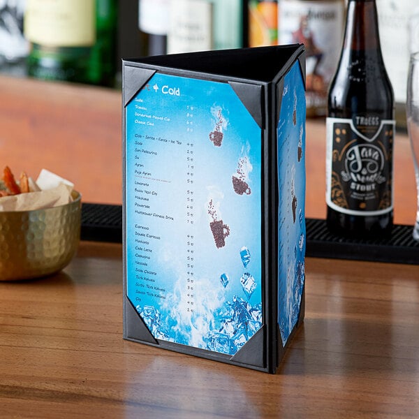 A Menu Solutions triple panel table tent on a table in a cocktail bar.
