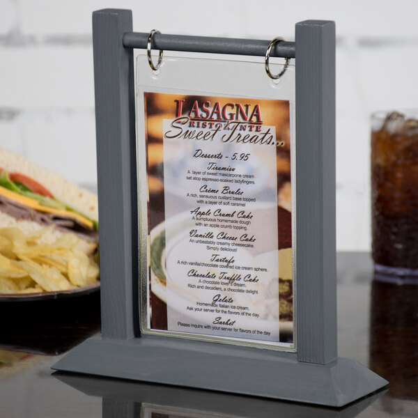 A Menu Solutions ash wood table tent on a table with a menu showing a sandwich.