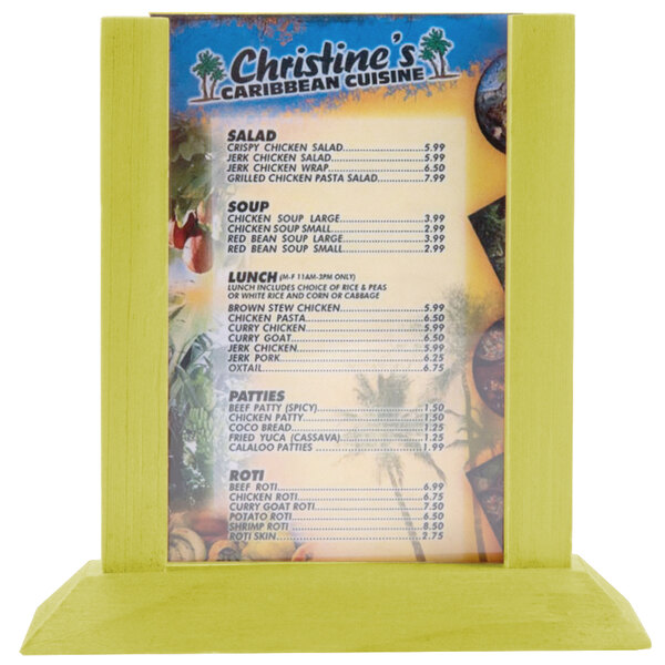 A Menu Solutions lime wood table tent holding a menu on a table with a yellow surface.
