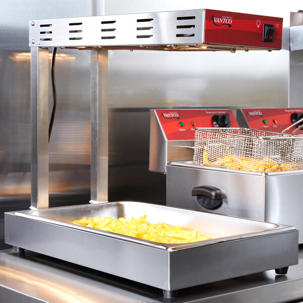 An Avantco freestanding infrared French fry warmer with a tray of French fries.