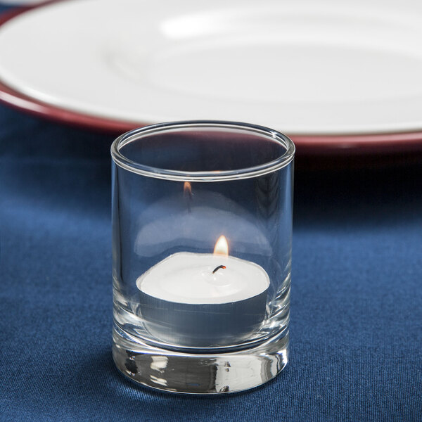 A Libbey Lexington shot glass used as a candle holder on a table.