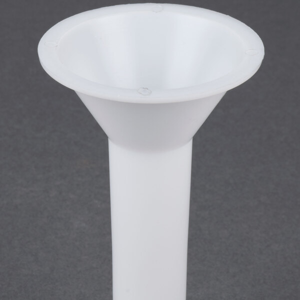 A white funnel with holes on a gray surface.