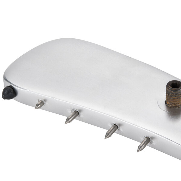 A silver rectangular object with metal spikes.