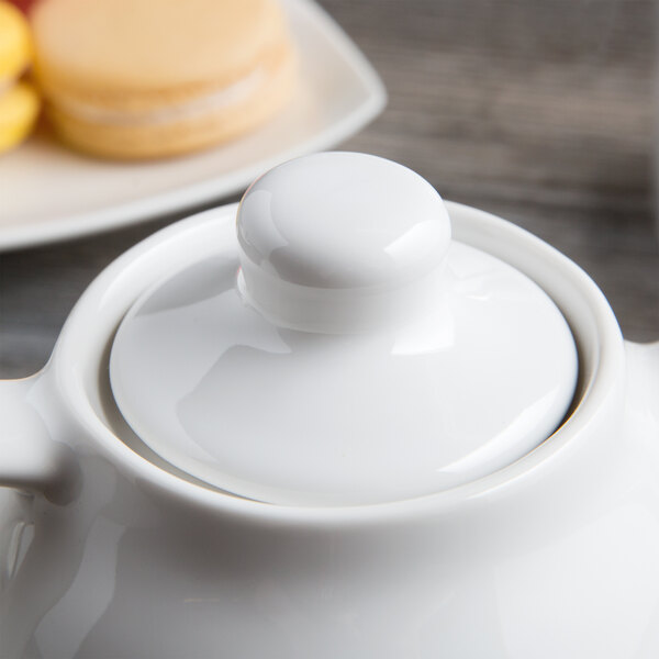 A close up of a Tuxton white china teapot with a lid.