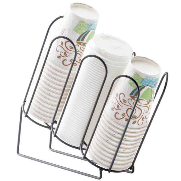 A black metal Cal-Mil angled countertop cup holder with stacked paper cups in one section.