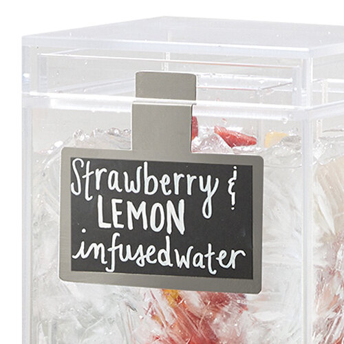 A Cal-Mil chalkboard sign on a container of ice and fruit with strawberry and lemon infused water.