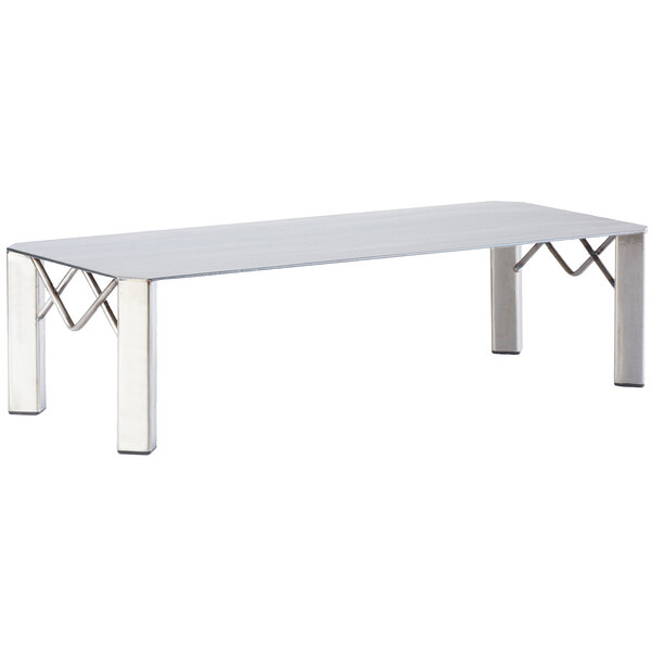 A Cal-Mil white rectangle riser with metal legs on a table.