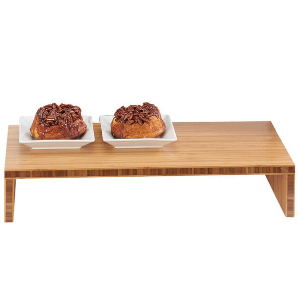 A bamboo stair step riser holding two plates of food on a table.