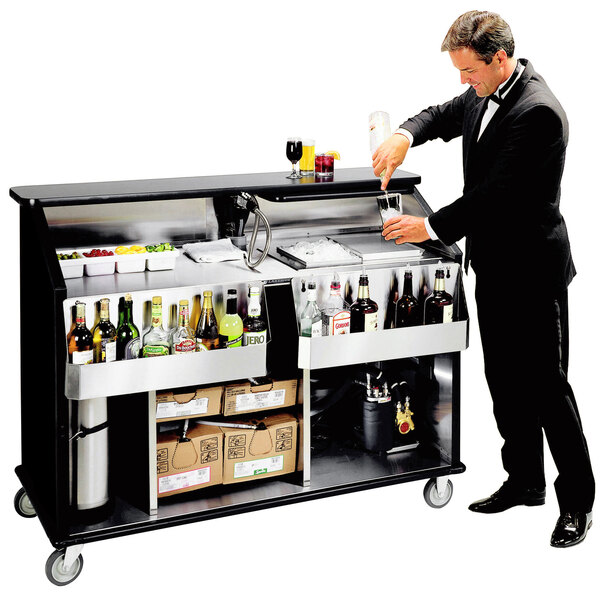 A man in a tuxedo pouring a drink into a glass at a Lakeside portable bar.
