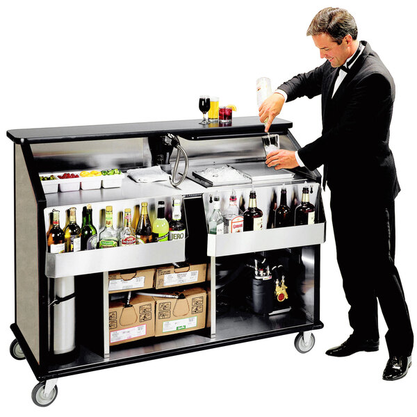 A man in a suit pouring a drink into a glass from a Lakeside portable bar.