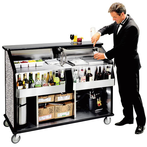 A man in a suit pouring a drink into a glass at a Lakeside portable bar.