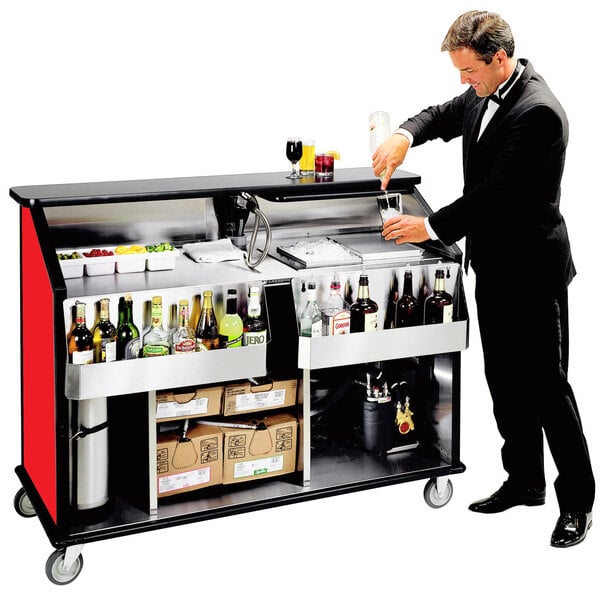 A man in a suit pouring a drink into a glass at a Lakeside portable bar.