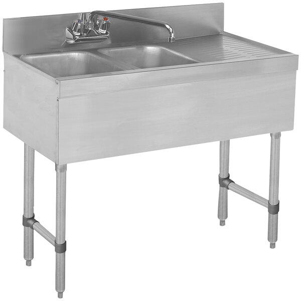A stainless steel Advance Tabco bar sink with two bowls and a left side drainboard.