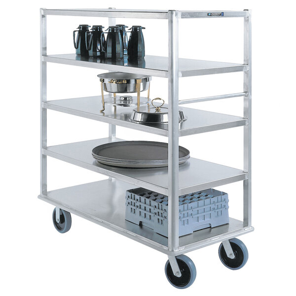 A Lakeside aluminum Queen Mary banquet cart with trays and plates on it.