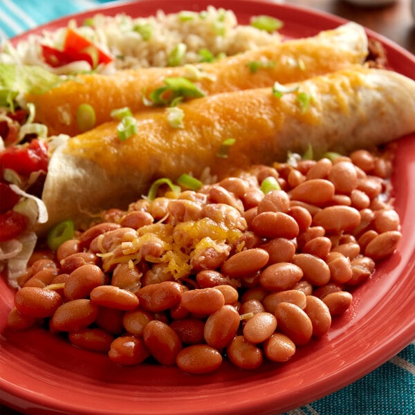 A plate of beans, rice, and cheese with a side of Furmano's pinto beans.